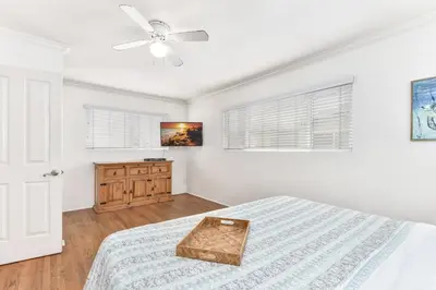 a white bedroom with a bed and a ceiling fan at 4 Bedroom Home with Rooftop & Peek-A-Boo Ocean View in Newport Beach