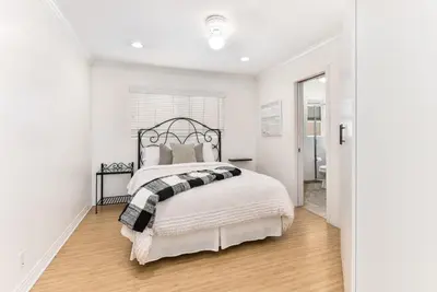 a white bedroom with a bed and a hallway at 4 Bedroom Home with Rooftop & Peek-A-Boo Ocean View in Newport Beach