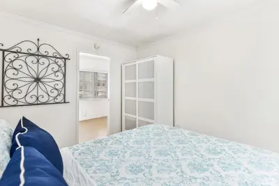 a white bedroom with a bed and a window at 4 Bedroom Home with Rooftop & Peek-A-Boo Ocean View in Newport Beach