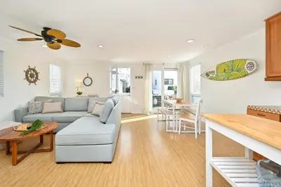 a living room with a couch and a table at Freshly Renovated Beach House Steps to the Beach in Newport Beach