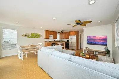 a living room with a couch and a table at Freshly Renovated Beach House Steps to the Beach in Newport Beach