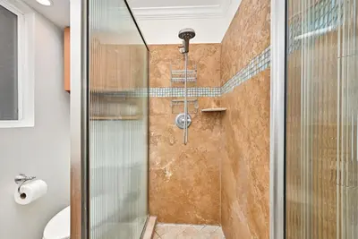 a shower with a glass door in a bathroom at Freshly Renovated Beach House Steps to the Beach in Newport Beach
