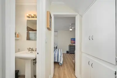 a white bathroom with a sink and a mirror at Freshly Renovated Beach House Steps to the Beach in Newport Beach