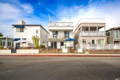 a white building on a city street at Freshly Renovated Beach House Steps to the Beach in Newport Beach