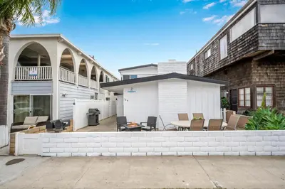 a house with a patio with a table and chairs at 2 Bedroom Upstairs with Balcony Steps from the Sand in Newport Beach