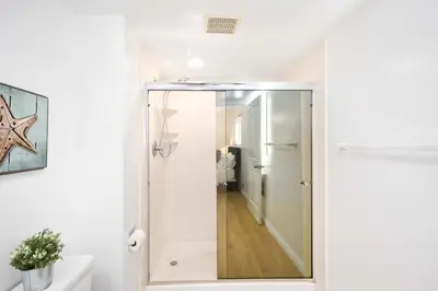 a bathroom with a shower with a glass door at 5 Bedroom Duplex 1 minute Walk to the Ocean in Newport Beach
