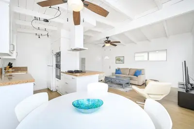 a kitchen and living room with a table and chairs at 5 Bedroom Duplex 1 minute Walk to the Ocean in Newport Beach
