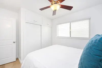 a white bedroom with a ceiling fan and a bed at Renovated 3 Bedroom Home on 41st-1 min walk to Beach in Newport Beach