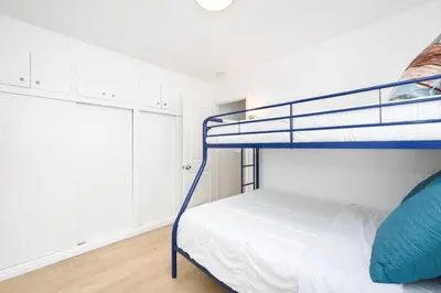 a bedroom with a bunk bed and white cabinets at Renovated 3 Bedroom Home on 41st-1 min walk to Beach in Newport Beach