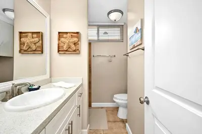 a white bathroom with a sink and a toilet at 5 Bedroom 4 Bath Duplex with Parking on 46th St! in Newport Beach