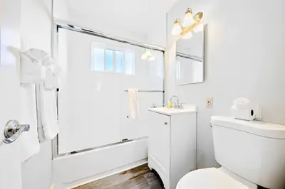a white bathroom with a toilet and a shower at 4 Bedroom Across from the Beach and Boardwalk in Newport Beach