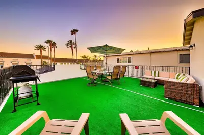a patio with green grass and a table and chairs at 4 Bedroom Across from the Beach and Boardwalk in Newport Beach