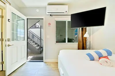 a bedroom with a bed and a door to a balcony at 4 Bedroom Across from the Beach and Boardwalk in Newport Beach
