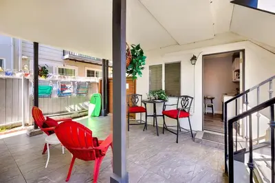 a balcony with red chairs and a table on a house at 4 Bedroom Across from the Beach and Boardwalk in Newport Beach