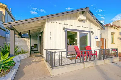 two red chairs sitting on the front porch of a house at Duplex Across the Street from Beach & Boardwalk in Newport Beach