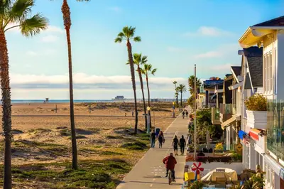 people walking down a sidewalk next to the beach at Duplex Across the Street from Beach & Boardwalk in Newport Beach
