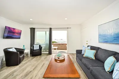 a living room with a couch and a table at Multi Level Oceanfront Home With Oceanviews and Private Patio on the Boardwalk in Newport Beach