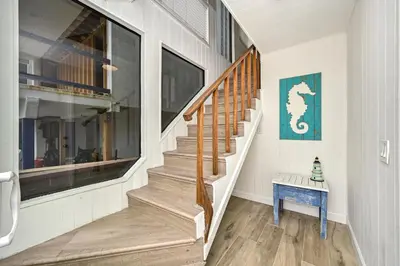 a staircase in a house with a blue table at Multi Level Oceanfront Home With Oceanviews and Private Patio on the Boardwalk in Newport Beach