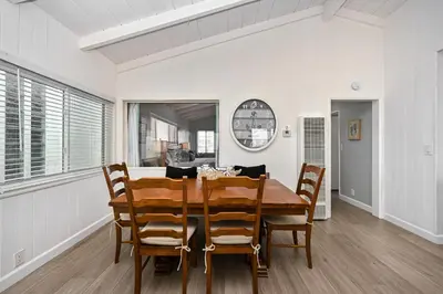 a dining room with a wooden table and chairs at Multi Level Oceanfront Home With Oceanviews and Private Patio on the Boardwalk in Newport Beach
