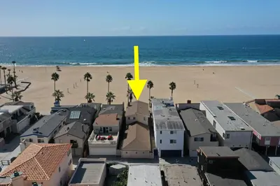 a yellow arrow on top of a building next to a beach at Multi Level Oceanfront Home With Oceanviews and Private Patio on the Boardwalk in Newport Beach