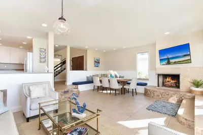 a living room and dining room with a fireplace at Multi Level Oceanfront Home With Oceanviews and Private Patio on the Sand in Newport Beach
