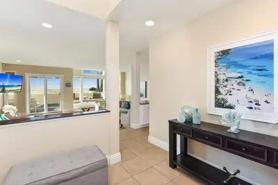 a living room with a large painting on the wall at Multi Level Oceanfront Home With Oceanviews and Private Patio on the Sand in Newport Beach