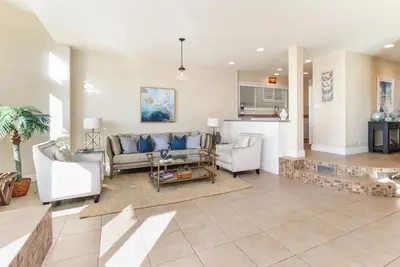 a living room with a couch and chairs at Multi Level Oceanfront Home With Oceanviews and Private Patio on the Sand in Newport Beach
