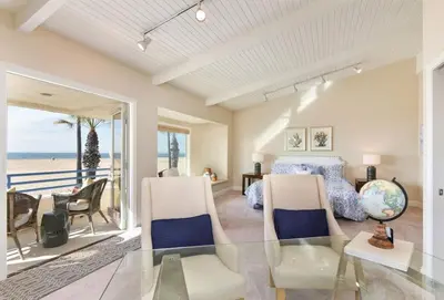 a living room with a glass table and a bedroom at 7 Bedroom Oceanfront Home & Back House in Newport Beach