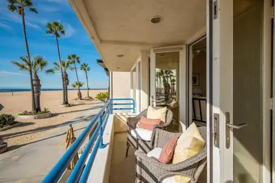 a porch of a house with chairs on the beach at 7 Bedroom Oceanfront Home & Back House in Newport Beach