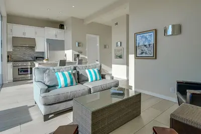 a living room with a couch and a table at New Renovated Beach Home with Ocean Views in Newport Beach