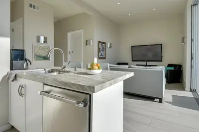a kitchen with a sink and a living room at New Renovated Beach Home with Ocean Views in Newport Beach