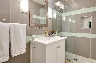 a bathroom with a white sink and a shower at New Renovated Beach Home with Ocean Views in Newport Beach
