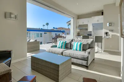 a living room with a couch and a table at New Renovated Beach Home with Ocean Views in Newport Beach