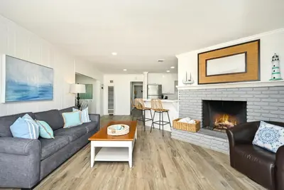 a living room with a couch and a fireplace at Updated Home with Patio on the Boardwalk near 15th St in Newport Beach