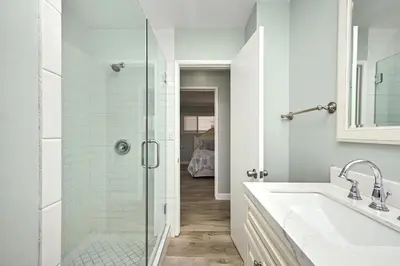 a bathroom with a glass shower and a sink at Updated Home with Patio on the Boardwalk near 15th St in Newport Beach