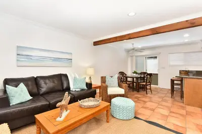 a living room with a leather couch and a table at 2 Bedroom BACK Apt at OCEANFRONT HOME on 15th St in Newport Beach