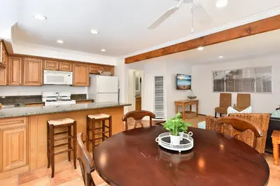 a kitchen and living room with a wooden table and chairs at 2 Bedroom BACK Apt at OCEANFRONT HOME on 15th St in Newport Beach