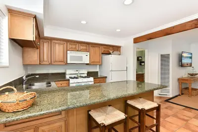 a kitchen with wooden cabinets and a counter top at 2 Bedroom BACK Apt at OCEANFRONT HOME on 15th St in Newport Beach