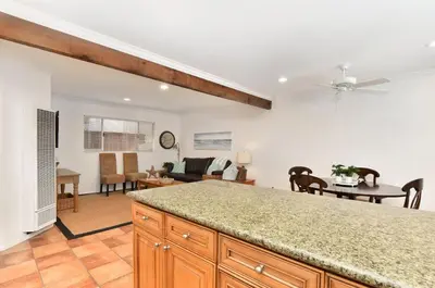 a kitchen with a counter top and a living room at 2 Bedroom BACK Apt at OCEANFRONT HOME on 15th St in Newport Beach