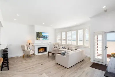 a living room with a couch and a fireplace at Luxury 4 Bedroom Oceanfront Home with AC in Newport Beach