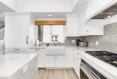 a white kitchen with white cabinets and a sink at Luxury 4 Bedroom Oceanfront Home with AC in Newport Beach