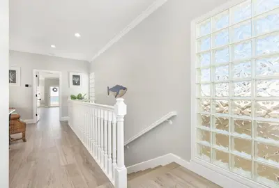 a white staircase with a large glass window at Luxury 4 Bedroom Oceanfront Home with AC in Newport Beach