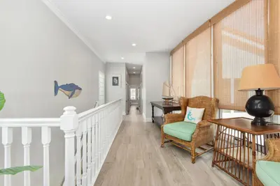 a hallway with a staircase with chairs and a table at Luxury 4 Bedroom Oceanfront Home with AC in Newport Beach