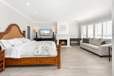 a bedroom with a bed and a fireplace at Luxury 4 Bedroom Oceanfront Home with AC in Newport Beach