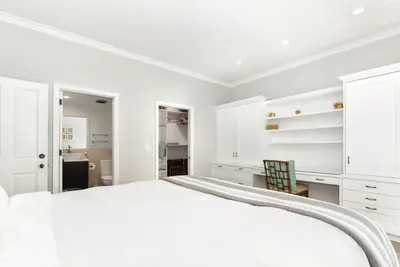 a white bedroom with a large bed and white cabinets at Luxury 4 Bedroom Oceanfront Home with AC in Newport Beach