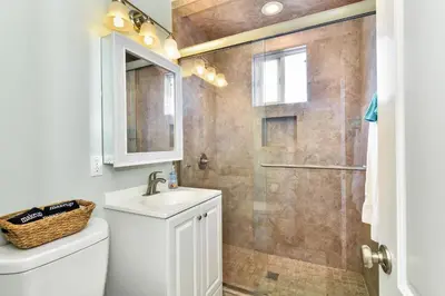 a bathroom with a shower and a sink and a toilet at Oceanfront Back Home with View of the Sea in Newport Beach
