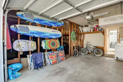 a garage with a surfboard and bikes in it at Oceanfront Back Home with View of the Sea in Newport Beach