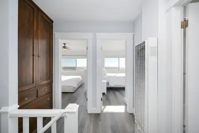a white room with a bedroom with two beds at Charming 2 Story and 4 Bedroom Home on the Boardwalk in Newport Beach