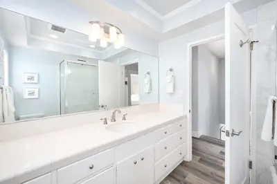a white bathroom with a large sink and a shower at 5 Bedroom Duplex on the Boardwalk next to Balboa Pier in Newport Beach