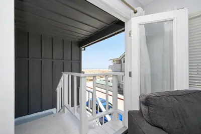 a room with a balcony with a view of the beach at 1 Bedroom Apartment in the back of our Oceanfront Home in Newport Beach